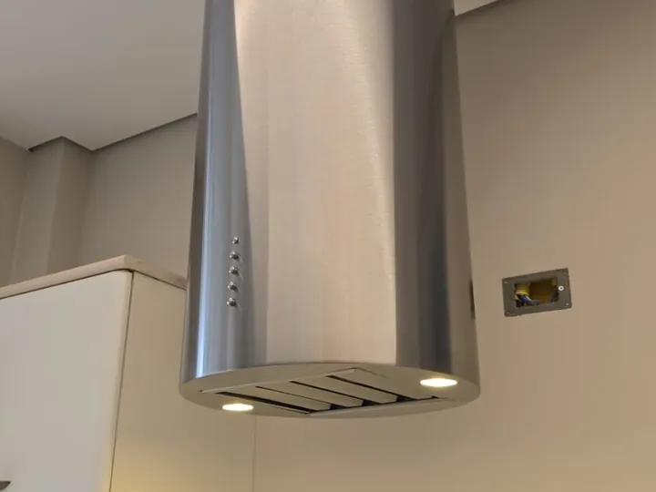 Detalhe de coifa tubular em aço inox com acabamento premium para instalação em ilha