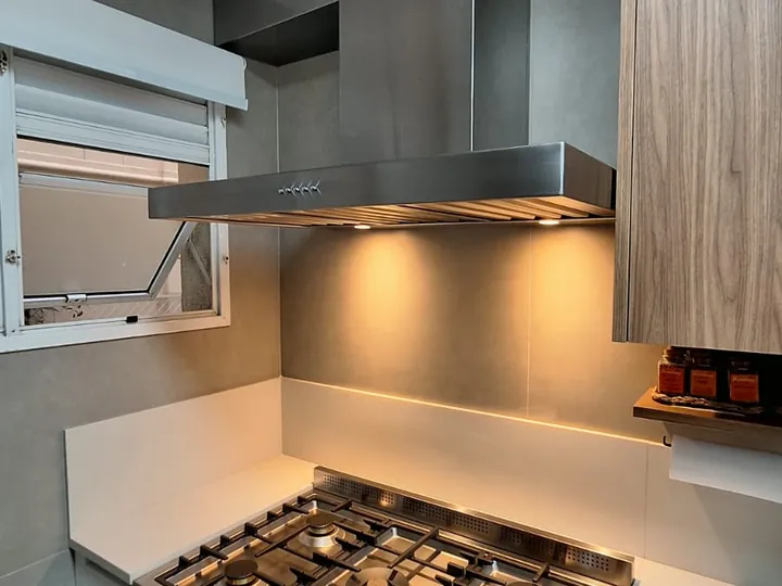 Coifa com duto horizontal em aço inox conduzindo a exaustão até a janela