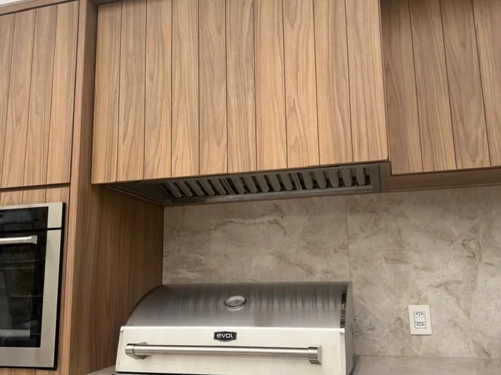 Coifa embutida em armário planejado instalada sobre fogão em cozinha