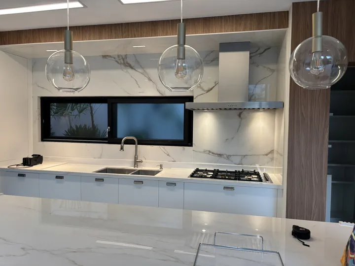 Coifa Slim de parede sob medida instalada sobre cooktop em cozinha gourmet