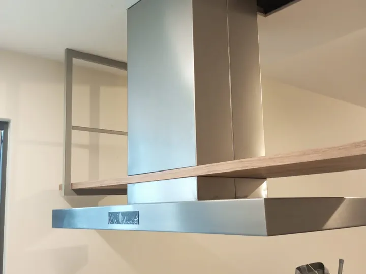 Coifa personalizada em aço inox sobre ilha com cooktop e churrasqueira