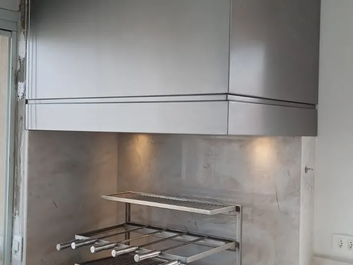 Coifa para churrasqueira sob medida em aço inox instalada na parede em espaço gourmet.